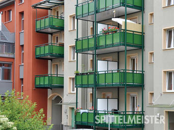 Freitragende Balkone aus Alu über Tordurchfahrt. Die Balkons rechts sind als Balkonturm auf 4 Stützen realisiert. Ebenfalls Aluminium.